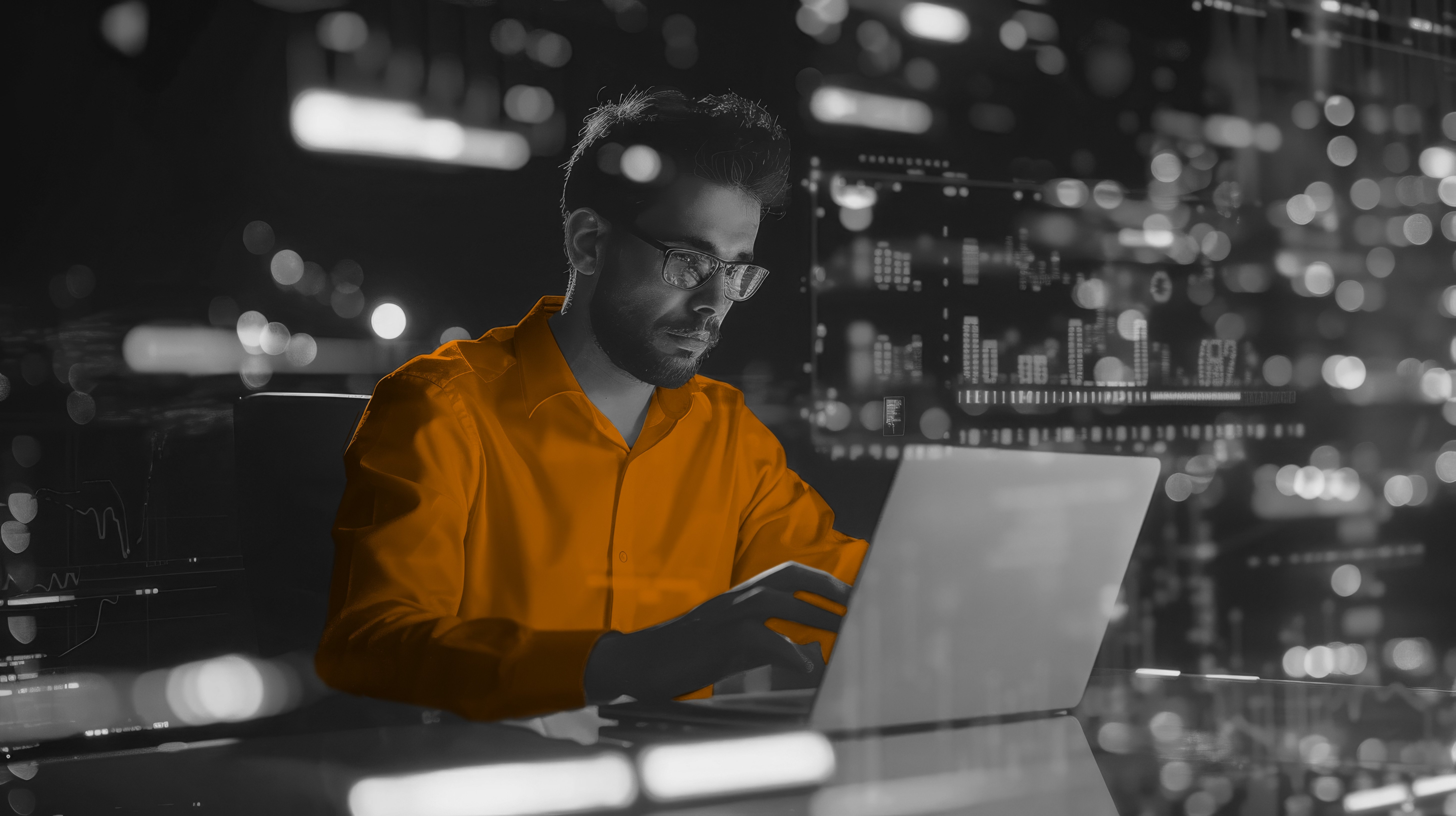 Man sat at a desk on a dark night with Data overlay